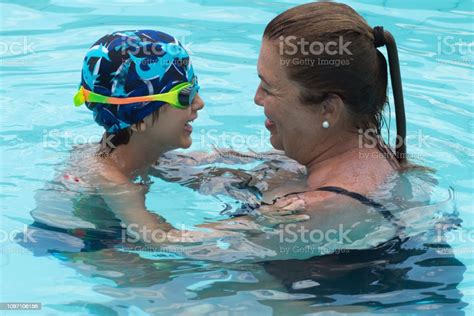 Lifestyle Grandmother Having Fun In The Swimming Pool With Grandson