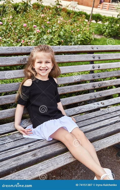 Little Girl Pretty Face Beautiful Kid Sitting On The Bench Stock Image