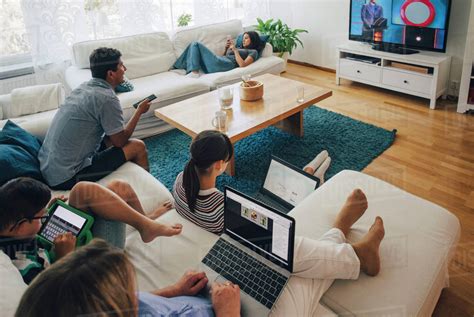 High angle view of family using technologies while relaxing in living room at home - Stock Photo ...