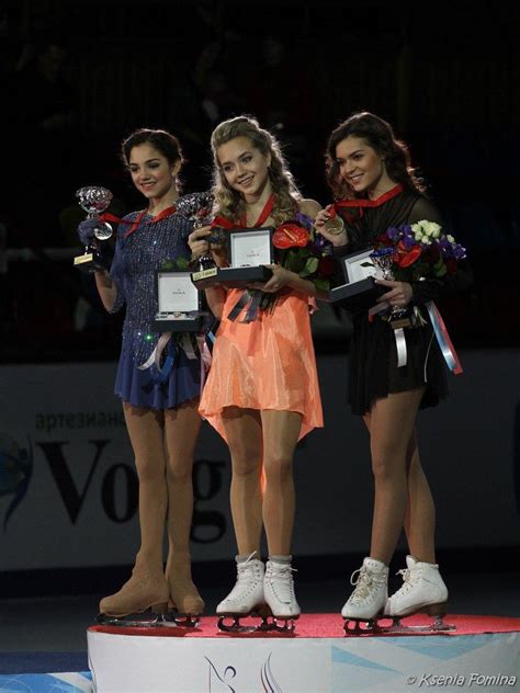 Three Women Standing On Top Of A Podium Holding Trophies