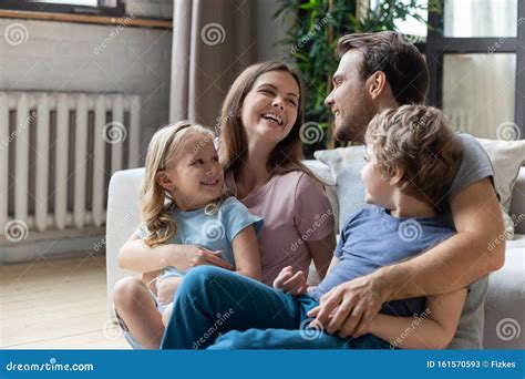 Happy Parents With Little Son And Daughter Sitting On Floor Stock Image