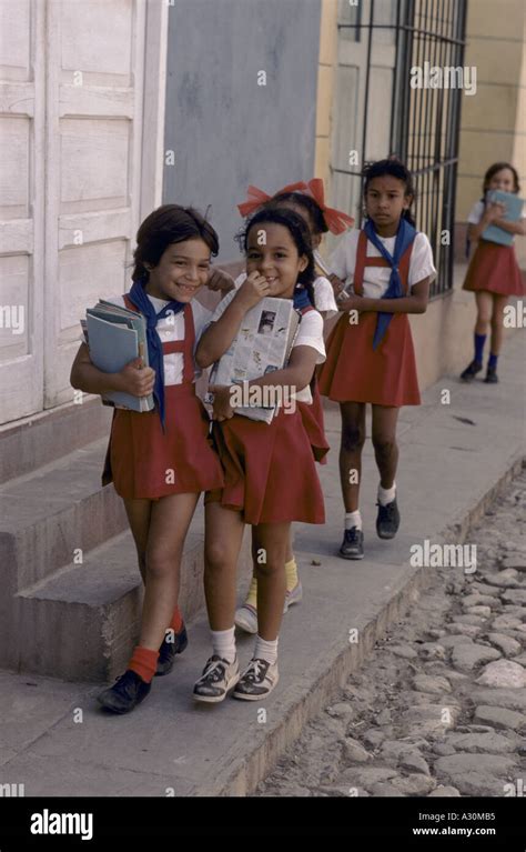 Cuban Girls Walking To School Holding Books And Wearing Red And White