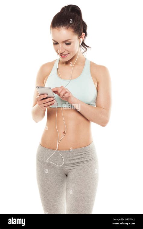 fitness girl with a smartphone on a white background enjoys sports training gym workout stock