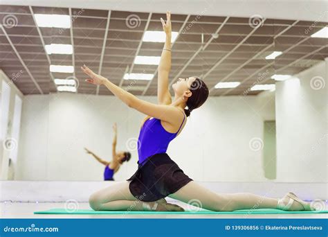 Female Ballet Dancer In Pointe Shoes Warming Up On The Mat Stock Photo