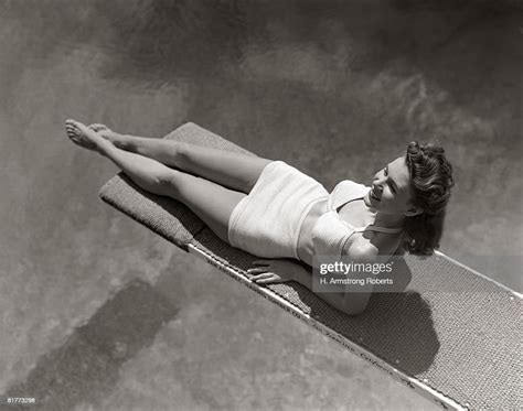 Woman Lying On Diving Board Over Pool Sunbathing Two Piece Bathing Suit
