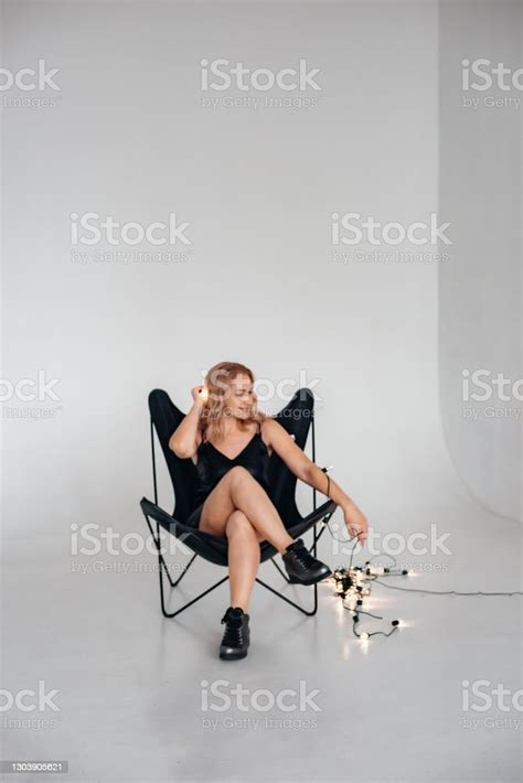 Schöne Mädchen Sitzt In Einem Stuhl Auf Einem Weißen Hintergrund