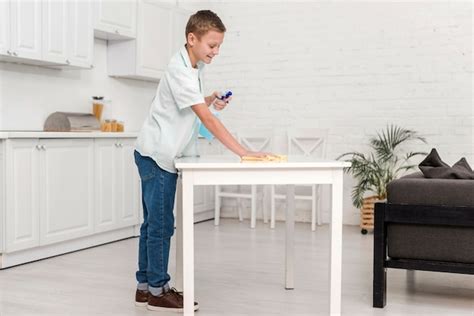 Free Photo Side View Of Boy Cleaning The Table