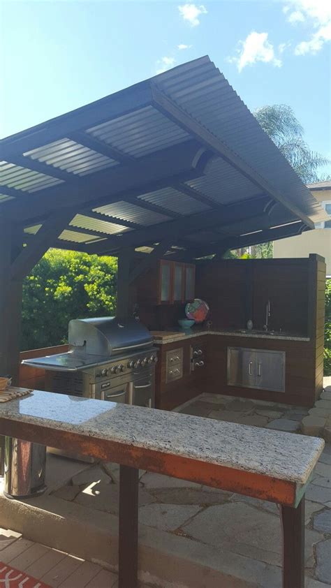 Step up your entertaining game with one of these diy outdoor kitchen plans that you can put outside on an existing patio, deck, or area of your yard. Cantilever corrugated sheet metal roof. | Outdoor kitchen ...