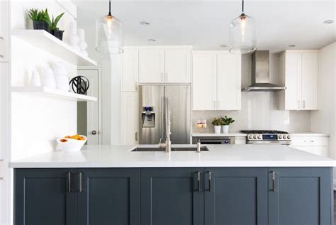 White shaker cabinets are a must! White kitchen with navy blue island. A pair of clear glass ...