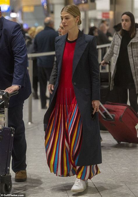 Rosamund Pike Is In High Spirits As She Lands In London Outfit