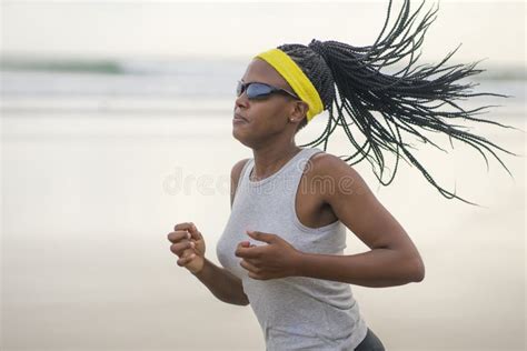 Determined African American Woman Running On The Beach Young