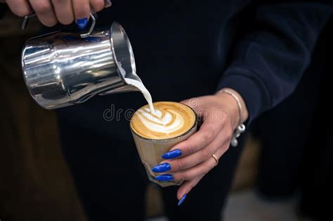 Close Up Hand Of A Woman Barista Pouring Froth Milk In Espresso Coffee