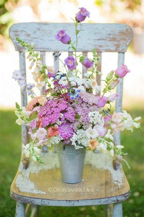 Create a garden inside your living room. Flowers in a tin bucket on a chair | Summer flowers ...