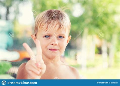 Cute Liitle Caucasian Blond Boy Smiling And Showing Peace Sign With