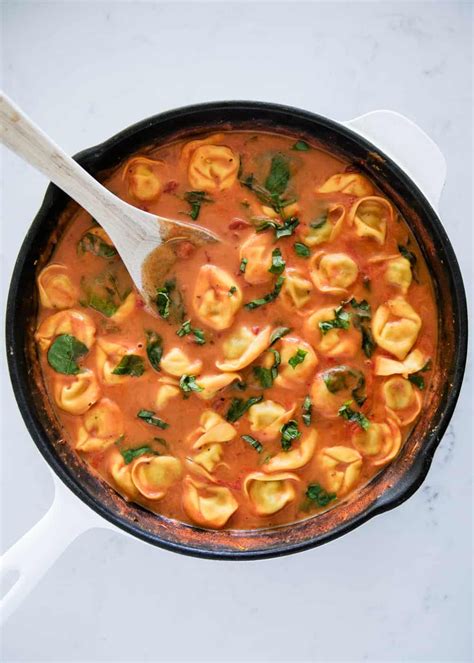 creamy tomato tortellini soup topped with fresh parmesan and basil an easy 30 minute meal that