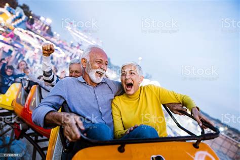 Carefree Seniors Having Fun On Rollercoaster At Amusement Park Stock 