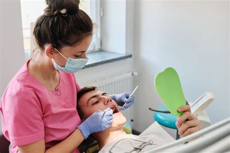 Dentist Examines Condition Of Teeth With Help Of Dental Mirror In