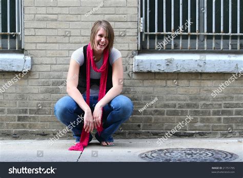 Girl Squatting By Wall Shutterstock