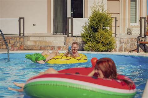 Couple Having Fun Splashing Water On Each Other At The Swimming Pool Stock Image Image Of