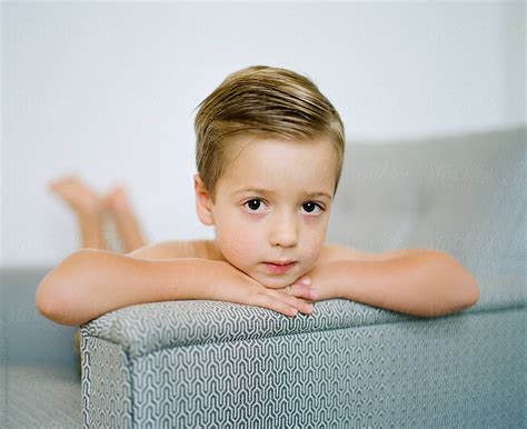 Portrait Of A Cute Young Boy Resting His Head On The Arm Of A Chair