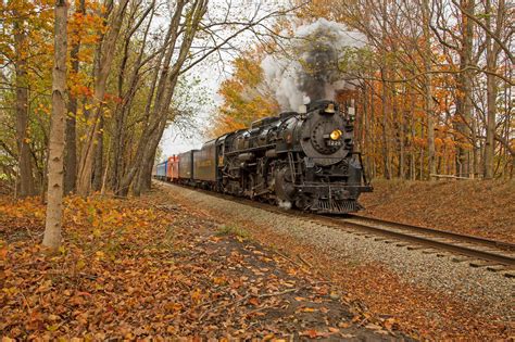 A Steam Locomotive Going Through A Forest In Fall
