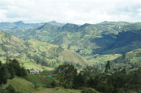 A Lush Green Valley With Mountains In The Background