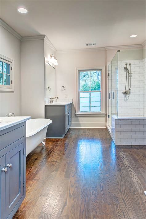 A Large Bathroom With Hardwood Floors And White Walls Along With A