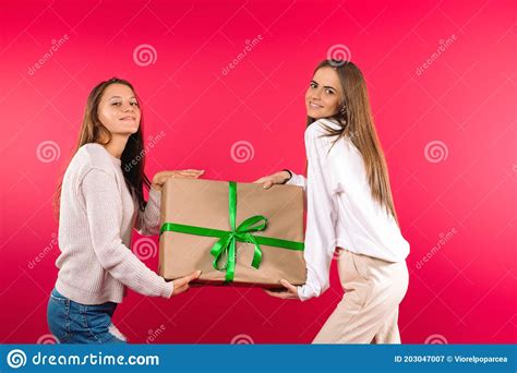 Beautiful Girls Posing With Big T Box On A Pink Background Holiday