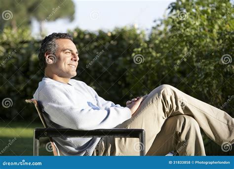 Man Sitting On Chair In Backyard Stock Photo Image Of Looking Person