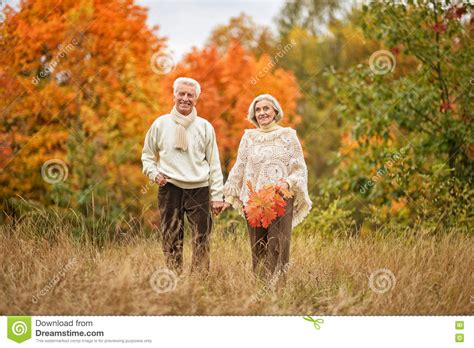 Beautiful Elderly Couple Walking In The Autumn Park Stock Photo Image