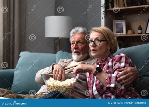 mature married couple entertaining observing terrified tv program senior husband and wife