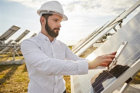 Professional Engineer In Hardhat Using Tablet For Checking Solar Panels