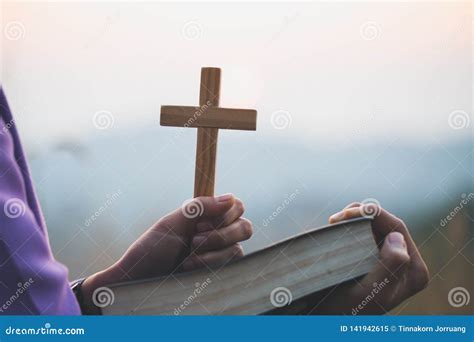 Woman Holding A Holy Bible And Cross In Her Hands And Praying In The