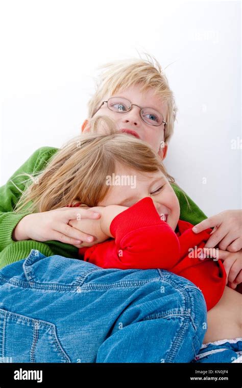 Two Young Siblings Fooling Around With Each Other Isolated On White