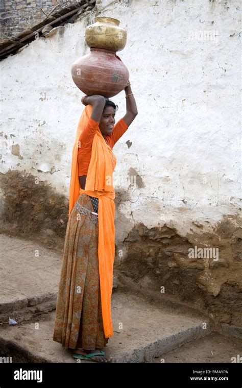 Rural Woman Carrying Water In Clay Pot On Her Head Standing In Village Lane Dilwara Udaipur