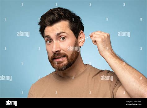 Funny Middle Aged Bearded Man Cleaning Ears With Cotton Swab Doing