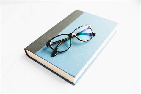 Book With Reading Glasses On White Background Bilder Und Fotos