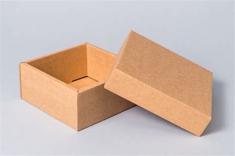 Caja de regalo de cartón abierto marrón con tapa sobre fondo gris