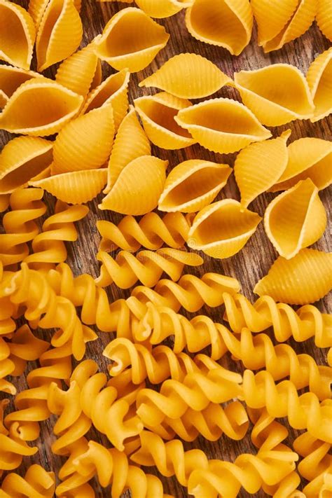 Background Of Italian Pasta Shaped Spiral And Shell Stock Photo