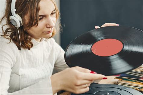 Young Woman Listening To Music From Vinyl Record Player Playing Music