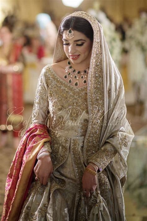 A Woman In A Bridal Gown Is Standing With Her Hand On Her Hip And