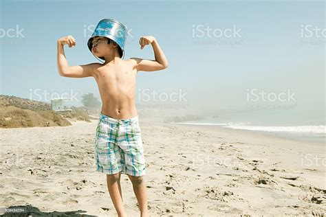 Boy With Bucket On Head Flexing Muscles Stock Photo Download Image
