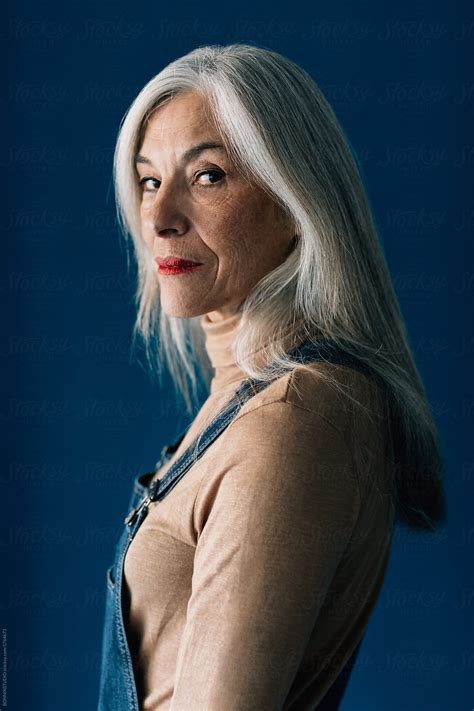 Portrait Of A Senior Woman With Grey Long Hair Looking At Camera By Stocksy Contributor