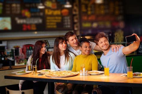Cheerful Multiracial Friends Having Fun Eating In Pizzeria Stock Image