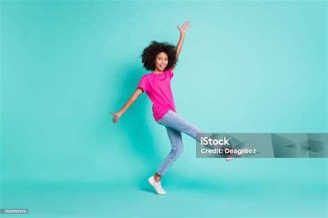 full length photo portrait of dancing black skin girl standing on one leg isolated on vivid cyan