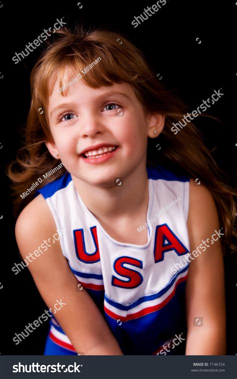 Cute Elementary Girl Cheerleading In Her Uniform Stock
