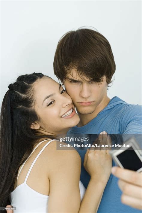 Young Couple Taking Self Portrait With Digital Camera Woman Smiling Man Furrowing Brow High Res