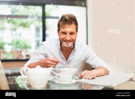 Smiling Man Eating Breakfast At Table Stock Photo Alamy