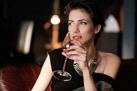 beautiful brunette woman drinking wine at the dinner party by stocksy contributor brkati