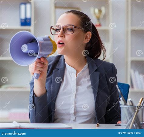 Angry Businesswoman Yelling With Loudspeaker In Office Stock Photo